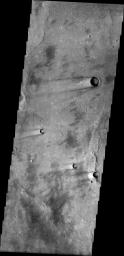 This image from NASA's Mars Odyssey spacecraft shows a portion of Syrtis Major Planum. There are several windstreaks with the classic dark rim/bright interior appearance.