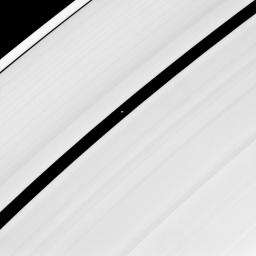 Saucer-shaped Pan glides through the Encke Gap in Saturn's rings in this image captured by NASA's Cassini spacecraft on June 10, 2008.