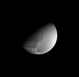 This view from NASA's Cassini spacecraft was taken from a vantage point 64 degrees above Saturn's moon Dione's equator, looking down onto the bright fractures that cover the moon's trailing side.
