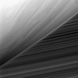 This bizarre scene from NASA's Cassini spacecraft shows the cloud-streaked limb of Saturn in front of the planet's B ring. The ring's image is warped near the limb by the diffuse gas in Saturn's upper atmosphere.
