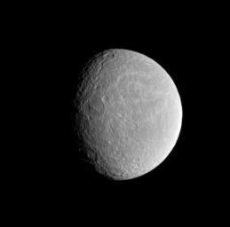 The sun's low angle near the terminator highlights the topography of craters within Rhea's wispy terrain in this image from NASA's Cassini spacecraft.