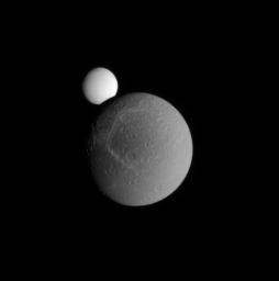 Enceladus peeks over the limb of Dione during a partial occultation. This image was taken in visible light with NASA's Cassini spacecraft's narrow-angle camera on Sept. 13, 2008.