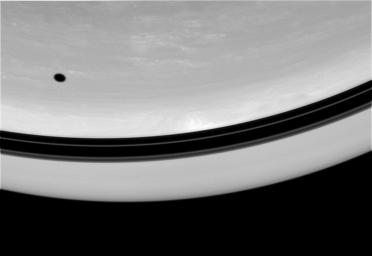 The shadow of Tethys drifts across the face of Saturn. Nearby, shadows of the planet's rings form a darkened band above the equator in this image captured by NASA's Cassini spacecraft on Oct. 1, 2008.