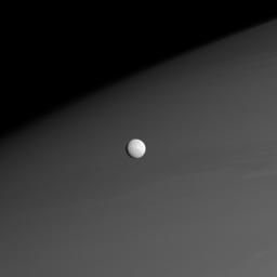 Against a background of muted atmospheric bands in Saturn's northern hemisphere, Mimas forges onward in its orbit around the Ringed Planet in this image taken by NASA's Cassini spacecraft on Nov. 26, 2008.
