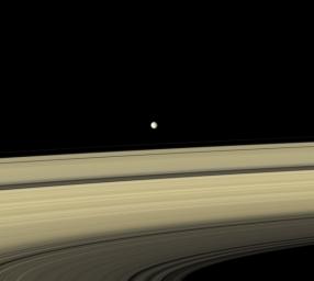 Gray Mimas appears to hover above the colorful rings as seen by NASA's Cassini spacecraft. The large crater seen on the right side of the moon is named for William Herschel, who discovered Mimas in 1789.