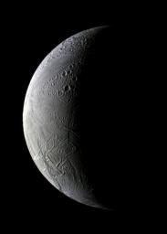 Sunrise uncovers both old and new Enceladus in this image from NASA's Cassini spacecraft. The lit side of the moon faces Saturn toward the left in this view of the trailing hemisphere.