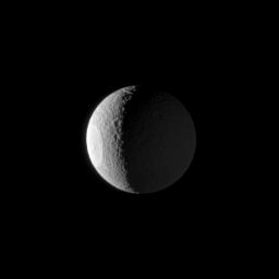 The huge Odysseus Crater is clearly illuminated by the sun on the western limb of Tethys, with Saturn shining from the right in this image from NASA's Cassini spacecraft taken on Jan. 22, 2009.