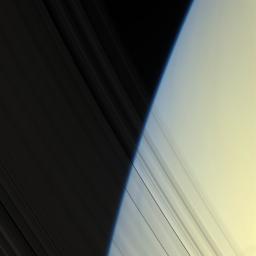NASA's Cassini spacecraft peers through Saturn's delicate, translucent inner C ring to see the diffuse blue limb of Saturn's atmosphere in this image taken on April 25, 2008.