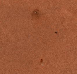 This enhanced-color image from NASA's Mars Reconnaissance Orbiter shows the Phoenix landing area viewed from orbit. With its solar panels deployed on the Martian surface, the spacecraft appears more blue than it would in reality.