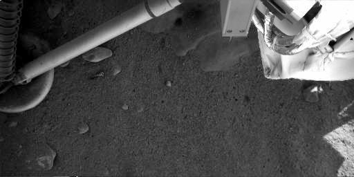 NASA's Phoenix Mars Lander shows that exhaust from the descent engine has blown soil off to reveal either rock or ice.