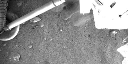 NASA's Phoenix Mars Lander shows the exhaust from its descent engine has blown soil off to reveal either rock or ice on the martian surface beneath it.