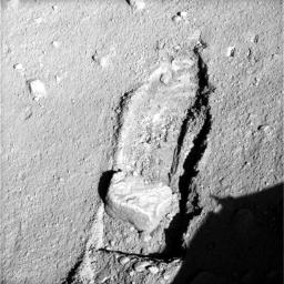 The robotic arm on NASA's Phoenix Mars Lander slid a rock out of the way on Sept. 22, 2008 to gain access to soil that had been underneath the rock called 'Headless,' after the arm pushed it about 16 inches from its previous location.