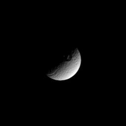 The terminator between shadow and light cuts across a large crater in the high southern latitudes of the moon Tethys in this image taken by NASA's Cassini spacecraft taken on Feb. 16, 2009.