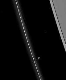 Saturn's moon Prometheus continues its dance with the planet's F ring, creating channels in the ring and streamers of extracted ring material as a result. This image is from NASA's Cassini spacecraft taken on April 16, 2009.