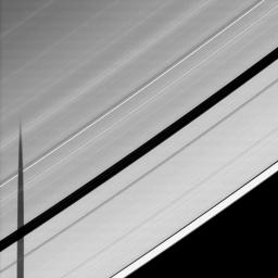 Seen from the unlit side of Saturn's A ring, the shadow of the moon Janus is cast across the Encke Gap.