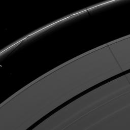 Saturn's moon Janus casts a shadow on the F and A rings while the moon Prometheus, seen on the left of the image, creates a streamer-channel in the thin F ring. This image is from as seen by NASA's Cassini spacecraft.