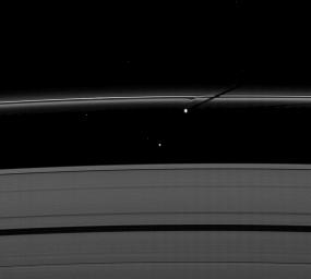 The moon Prometheus casts a shadow on Saturn's F ring near a streamer-channel it has created on the ring. The image was taken by NASA's Cassini spacecraft as the planet approached its August 2009 equinox.