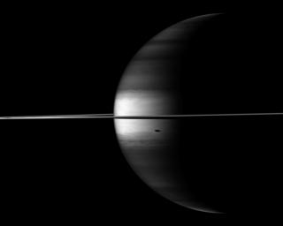 NASA's Cassini spacecraft's camera looks in near-infrared light at a dramatic view of Saturn, its ringplane and the shadows of a couple of its moons.