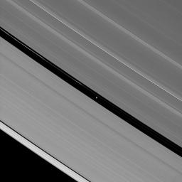 In the center of this image taken by NASA's Cassini spacecraft, the shadow of Pan is a short streak thrown over the edge of the A ring where Pan travels its path through the Encke Gap.