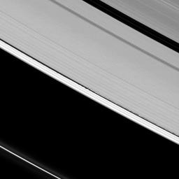 Tall vertical structures created by Saturn's moon Daphnis rise above the planet's otherwise flat, thin disk of rings to cast long shadows in this image taken by NASA's Cassini spacecraft on April 13, 2009.