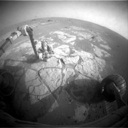 This image taken on March 13, 2009 by the front hazard-avoidance camera on NASA's Mars Exploration Rover Opportunity shows the rover's arm extended to examine the composition of a rock using the alpha particle X-ray spectrometer.