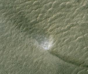 This telescopic view from orbit around Mars catches a Martian dust devil in action in the planet's southern hemisphere. The swirling vortex of dust can be seen near the center of the image.