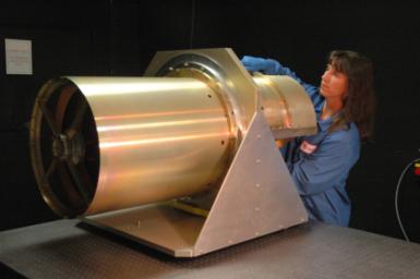 This image shows NASA's 40 cm diameter Wide-field Infrared Survey Explorer telescope. Here the lead optical test engineer attaches the back-end imager optics to the afocal.
