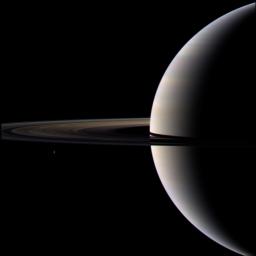 Looking cool and serene, Saturn shares its soft glow with NASA's Cassini Orbiter. Also seen are Saturn's ring and its icy moon Tethys.