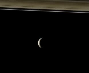 NASA's Cassini Orbiter peers toward the distant, icy plains of Saturn's moon Tethys. The planet's A and F rings slice across the top of this view.