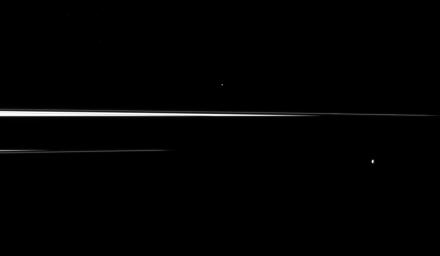 Saturn's shadow interrupts the planet's rings, leaving just thin slivers of the rings visible in this image, which shows a pair of the planet's small moons. Helene is in the center top of the image, Epimetheus is in the lower right.