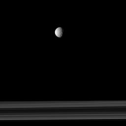 The cratered moon Mimas appears as if it has been hung like an ornament above Saturn's rings in this image taken by NASA's Cassini spacecraft.
