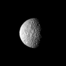 The oblate moon Mimas displays the cratered surface of its anti-Saturn side in this image taken by NASA's Cassini spacecraft.