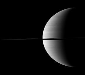 The diminutive moon Mimas can be found hiding in the middle of this view of a crescent of Saturn bisected by rings in this image captured by NASA's Cassini spacecraft. Mimas appears as a dark speck just about the ringplane near the center of the image. Th