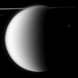 NASA's Cassini spacecraft captures a 'mutual event' between Titan and Mimas in front of a backdrop of the planet's rings. This image was snapped shortly before Saturn's largest moon passed in front of and occulted the small moon Mimas.
