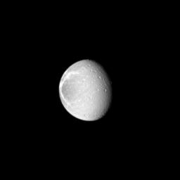 Sunlight highlights the bright, wispy features on the trailing hemisphere of Saturn's moon Dione as seen by NASA's Cassini spacecraft. These wispy features are a system of braided canyons with bright walls caused by fractures.