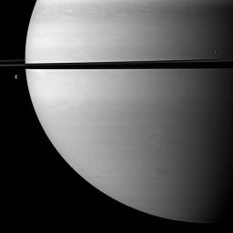 Two moons orbit serenely before Saturn while large storms churn through the planet's southern hemisphere in this image taken by NASA's Cassini spacecraft. The moon Mimas is on the right. Dione is on the left.