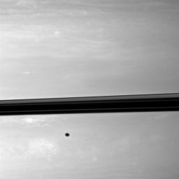 Appearing like a freckle on the face of Saturn, a shadow from the moon Enceladus blemishes the planet just below the ringplane in this NASA Cassini spacecraft image.