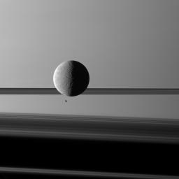Saturn's moon Rhea looms 'over' a smaller and more distant Epimetheus against a striking background of planet and rings. The two moons aren't actually close to each other.
