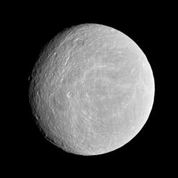 NASA's Cassini spacecraft looks toward the cratered plains of the trailing hemisphere of Rhea. Some of the moon's fractures, appearing like wispy bright lines, can be seen on the left of the image.