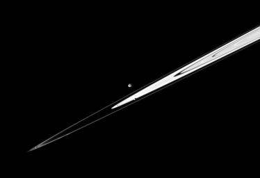 A pair of Saturn's small satellites, Janus and Pandora, accompany the planet's rings in this image from NASA's Cassini spacecraft presenting the view in dramatic diagonal fashion.