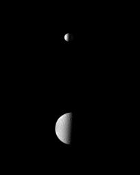 The smaller moon Mimas upstages the larger moon Dione as the dramatic Herschel Crater is spotlighted on Mimas in this view from NASA's Cassini spacecraft.