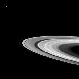 Bright spokes grace Saturn's B ring in this Cassini spacecraft snapshot that also features a couple of the planet's moons large and small. Dione can be seen in the upper left of the image while Pandora appears as a small speck beyond the thin F ring.