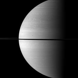 The immense size of Saturn is emphasized in this portrait by NASA's Cassini spacecraft that features the moon Mimas shown in front of the planet. Mimas appears as only a small dot above the rings near the center of the image.