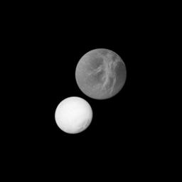 At top of this image, Saturn's moon Dione may appear closer to the spacecraft because it is larger than the moon Enceladus in the lower left. However, Enceladus was actually closer to the spacecraft in this image captured by NASA's Cassini spacecraft.
