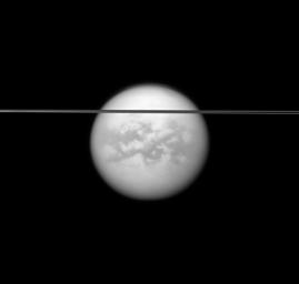 Saturn's rings cut across this view of the planet's largest moon, Titan. Dark albedo features on Titan (5,150 kilometers, or 3,200 miles across) and the moon's north polar hood are visible in this image captured by NASA's Cassini spacecraft.