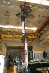 In the middle of this image taken at the Jet Propulsion Laboratory, the long robotic arm of NASA's Mars Science Laboratory rises straight up toward the ceiling of the lab where it is being tested.
