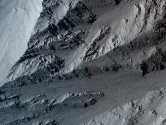 This image taken by NASA's Mars Reconnaissance Orbiter covers the northern edge of the largest volcano in the solar system, Olympus Mons on Mars; its margin is defined by a massive cliff many kilometers (several miles) tall.