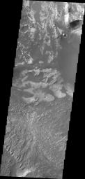 This image taken by NASA's 2001 Mars Odyssey shows a portion of the floor of Melsa Chasma. Wind blown material is located in lows between layered floor materials.