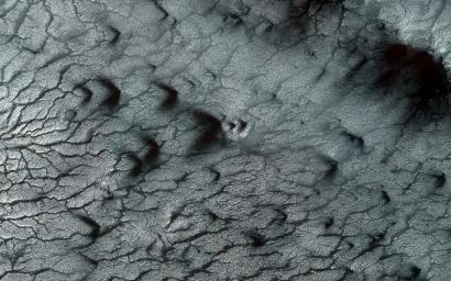 Southern spring on Mars brings sublimation of the seasonal dry ice polar cap as seen by NASA's Mars Reconnaissance Orbiter.