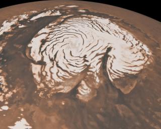 This image, combining data from two instruments aboard NASA's Mars Global Surveyor, depicts an orbital view of the north polar region of Mars. To the right of center, a large canyon, Chasma Boreale, almost bisects the white ice cap.